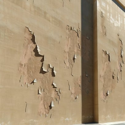 realistic picture of paint peeling from a large stucco building