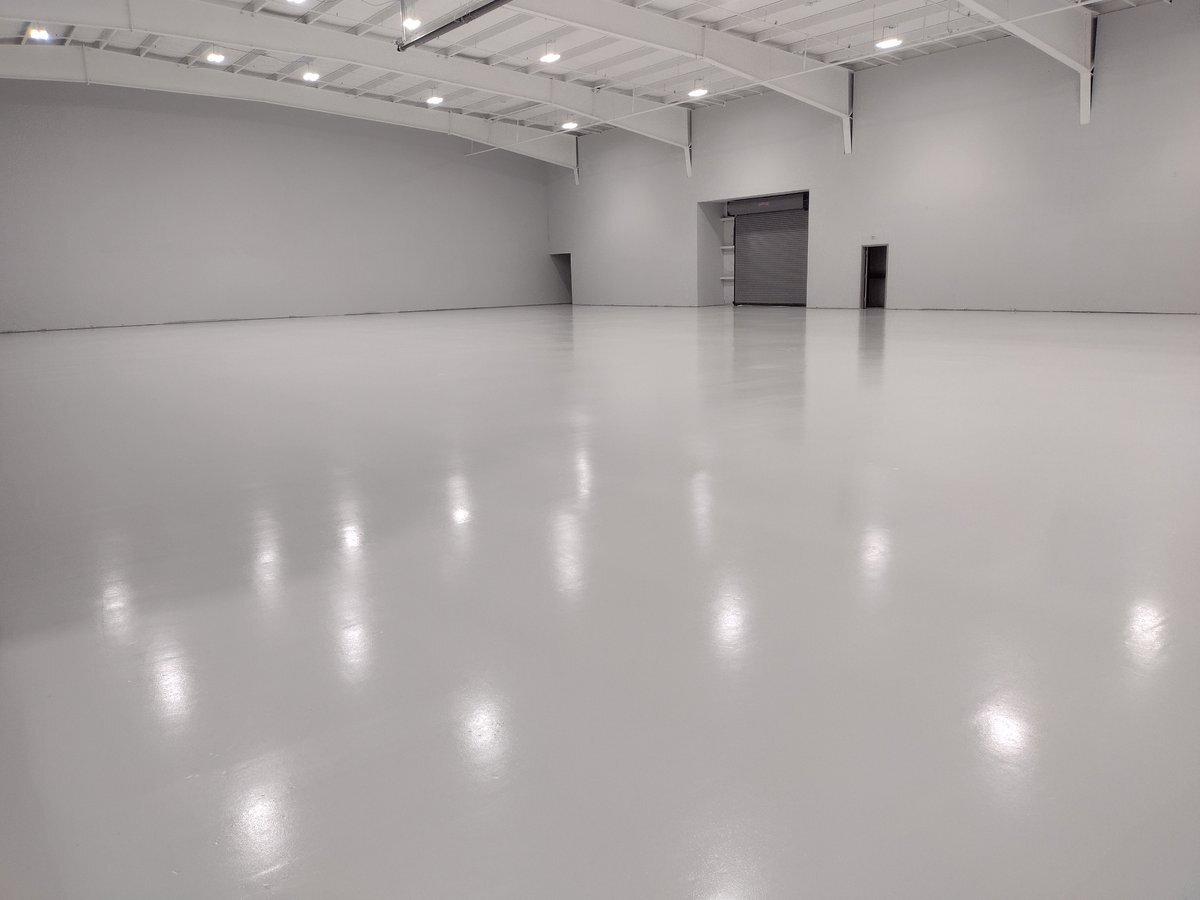 Large empty warehouse with a white high-gloss resinous floor