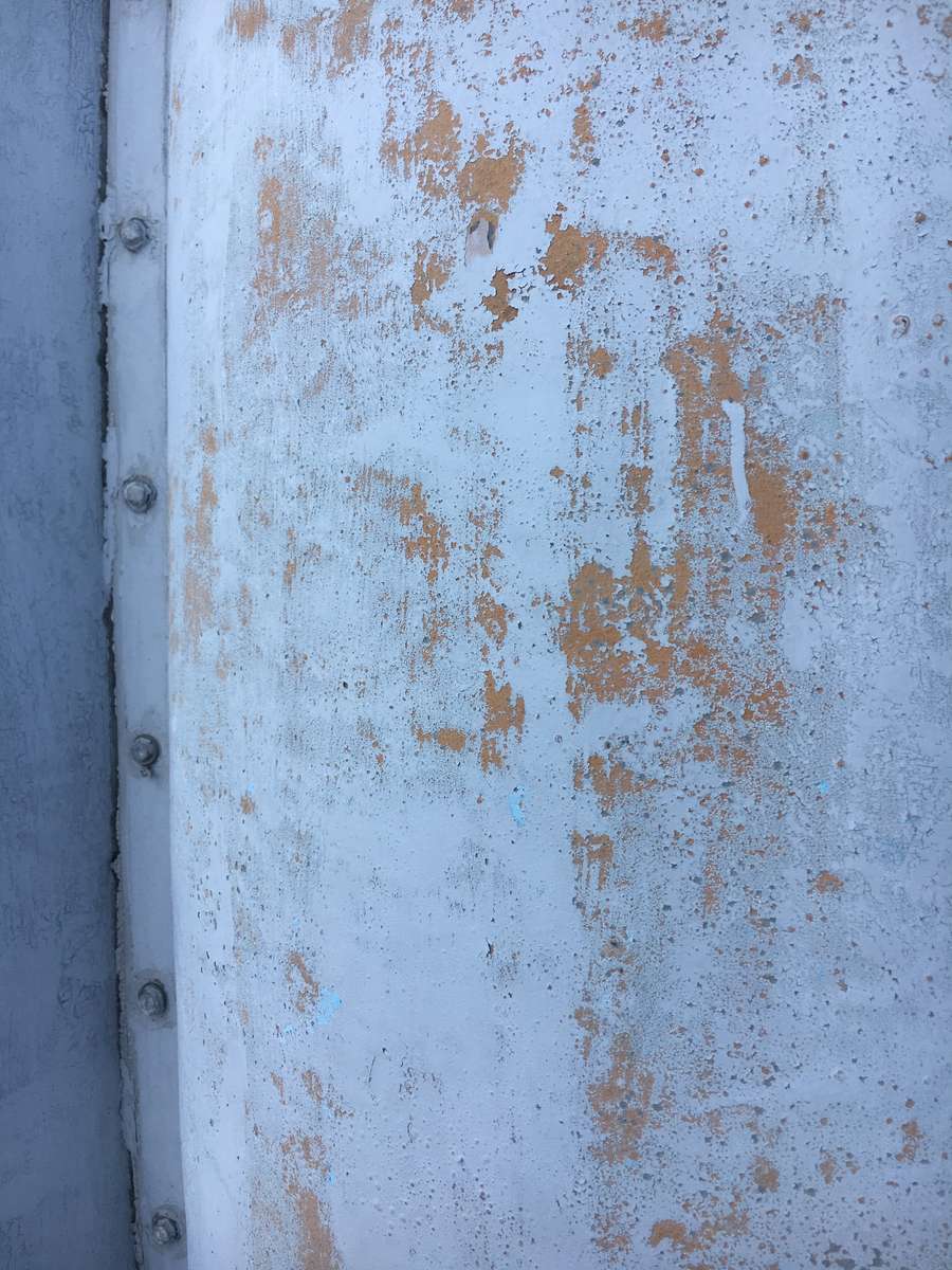 Close-up of a coating cracking and flaking from metal