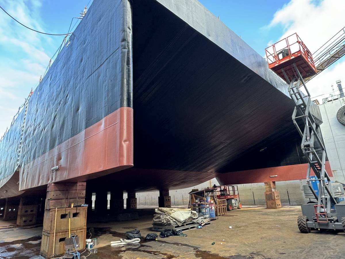 Black and red coated barge hull on blocks